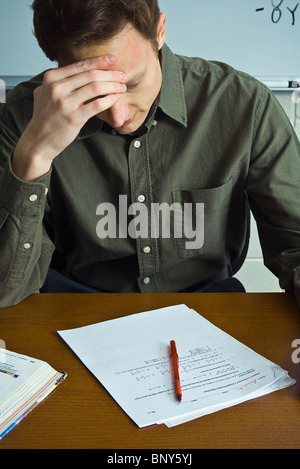 Lehrer benoten von zu Hause aus arbeiten Übungen, Kopf haltend Stockfoto