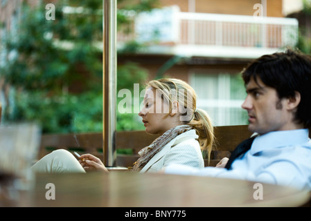 Unglückliche paar sitzt im Freien, Frau raucht eine Zigarette Stockfoto