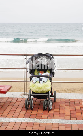 Baby im Kinderwagen auf der Promenade mit Blick auf Strand allein  Stockfotografie - Alamy