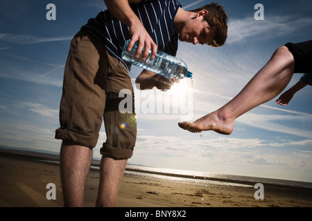 Mann Womans Fußwaschung am Strand Stockfoto