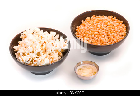 Schalen mit Mais, Popcorn und zerlassener Butter auf weißem Hintergrund Stockfoto