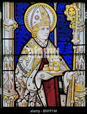 Ein Buntglasfenster von Geoffrey Webb, das den Heiligen Nikolaus von Myra mit drei Säcken Gold zeigt, All Saints Church, Ladbroke, Warwickshire Stockfoto