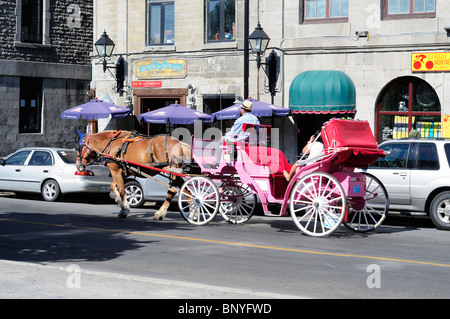 Zwei Touristen genießen einen Pferd gezeichneten Buggy fahren auf den Straßen der Altstadt von Montreal Stockfoto