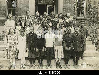 Ca. 1900 Schule Foto zeigt eine Gruppe von kaukasischen 9-11 Jahre alt mit einem afrikanischen amerikanischen Mädchen. Stockfoto