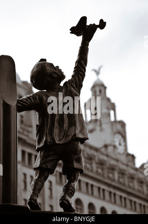 Statue eines jungen mit einem Spielzeug-Flugzeug in der unserer Dame und Str. Nicholas Church Garten.  Im Hintergrund ist das Leber-Gebäude.  Die Statue Comemerates Liverpudleans verstorbenen im Blitz.  Bildhauer: Tom Murphy Stockfoto