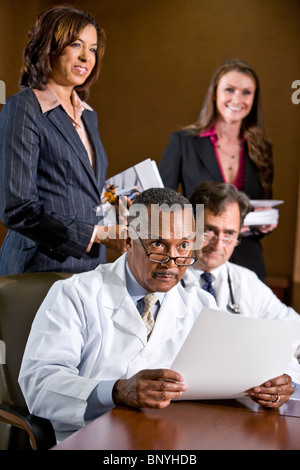 Reife afrikanische amerikanische Arzt im Hinblick auf Papiere Stockfoto