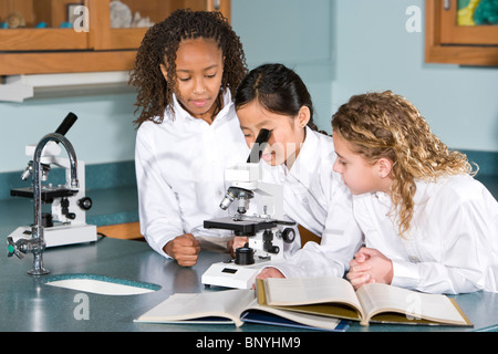 Multi-ethnischen Grundschulkinder im Science-Lab mit Mikroskop Stockfoto