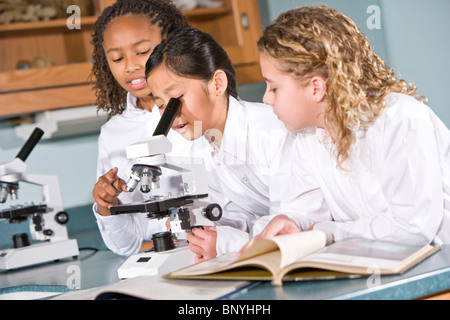 Grundschulkinder im naturwissenschaftlichen Unterricht mit Mikroskop Stockfoto