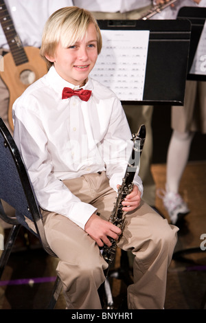 Junge sitzt durch Notenständer mit Klarinette Stockfoto
