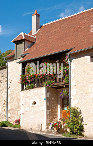 Hängende Körbe und Pflanzer auf Holzbalkon renoviertes Steinhaus - Frankreich. Stockfoto