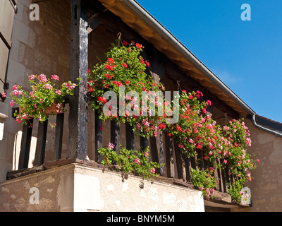 Hängende Körbe und Pflanzer auf Holzbalkon renoviertes Steinhaus - Frankreich. Stockfoto