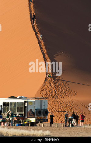 Touristen, die Düne 45 im Sossusvlei in Namibia Naukluft Park zentrale Namibwüste aufsteigend Stockfoto