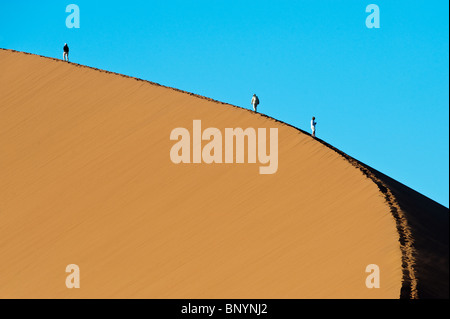 Touristen, die Düne 45 im Sossusvlei in Namibia Naukluft Park zentrale Namibwüste aufsteigend Stockfoto