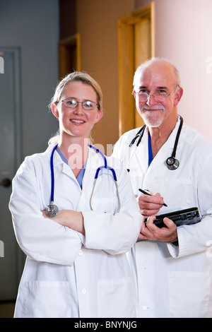 Junge Ärztin stehend mit älteren männlichen Kollegen Stockfoto