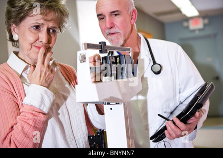 Arzt mit einem Gewicht von senior Frau im Maßstab Stockfoto