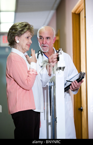 Arzt mit einem Gewicht von senior Frau im Maßstab Stockfoto