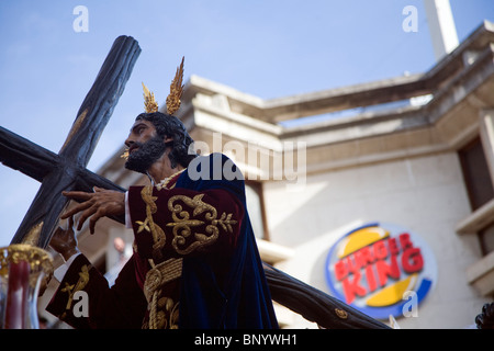 Jesus, ein Kreuz zu tragen, während die Osterprozession, Sevilla, Spanien Stockfoto