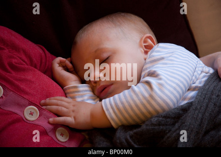 Baby Junge (16 Monate alt) schläft auf seiner Mutter Brust. Stockfoto