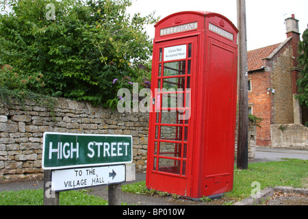 Eine traditionelle rote Telefonzelle auf einer Straße in einem Dorf U.K. Stockfoto