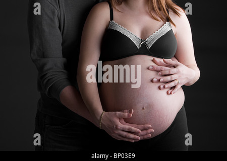 Aufnahme von Mutter und Vater unterstützen schwangere Bump Stockfoto