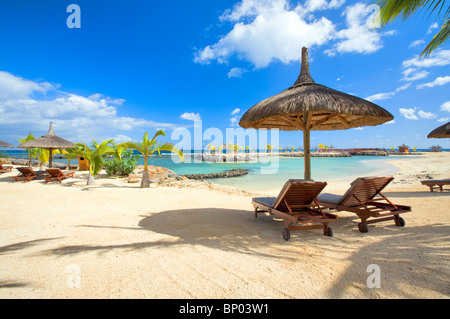 Strand-Szene mit Stroh Sonnenschirme, Mauritius Stockfoto