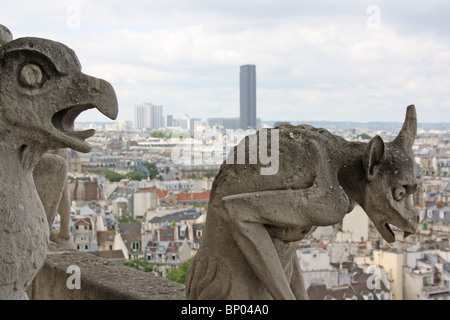 Kathedrale Notre Dame, Paris.  Chimären 20 & 21 auf dem Balkon, mit Tour Montparnasse im Hintergrund. Stockfoto