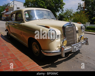 Elfenbein Mercedes Benz 190 Oldtimer auf der Straße in Luang Prabang, Nordlaos Stockfoto