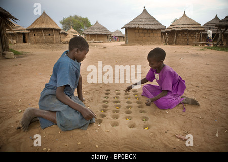 Mädchen spielen im Flüchtlingslager Acowa, Amuria District, NE Uganda das Brettspiel Mankala (oder Mancala). Stockfoto