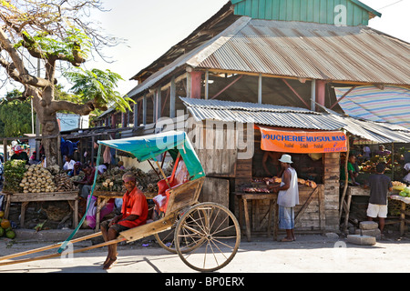 Pousse-pousse Rikscha und Fahrer außerhalb einer Halal Metzgerei im Markt/Toliara Tulear/Tulear, Atsimo Andrefana, Süd-westen Madagaskar Stockfoto