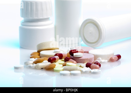 Haufen von Medizin Pillen, Tabletten und Kapseln vor der ihre Flaschen und Behälter Stockfoto