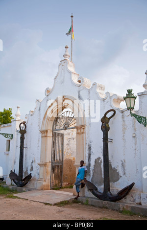 Mosambik, Ihla de Moçambique, Stone Town. Ein junger Mann lehnt sich an die alten Marineakademie in Stone Town. Stockfoto