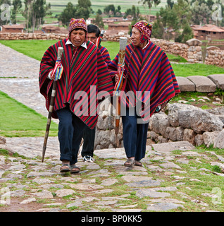 Peru, Gemeinde gewählte Vertreter, Mitarbeiter des Büros in der hand, auf gepflasterten Wegen in Chinchero schreiten Stockfoto