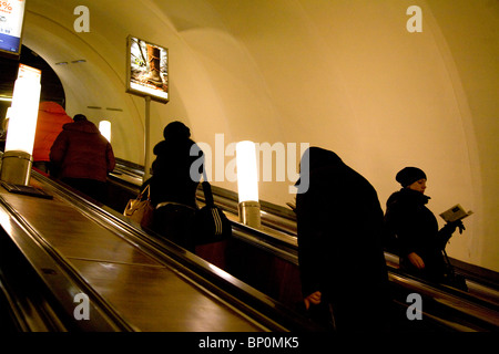 Russland, St. Petersburg; In einem von der Metro-Stationen mit einem Mädchen Buch ein die Rolltreppe hinunter Stockfoto