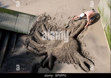 Eine Straße Künstler schaffen eine Sandskulptur einer Krabbe Strandhotel Thames, London Stockfoto