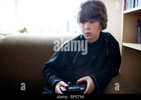 Ein kleiner Junge auf einer PlayStation spielen Stockfoto