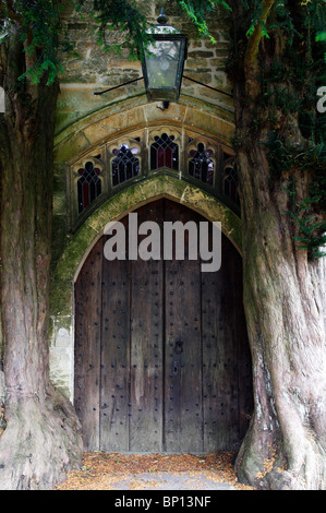 Alte Kirche Tür zwischen Eibe Bäume, 'St. Edwards' Kirche, Stow auf die würde, Cotswolds, UK Stockfoto