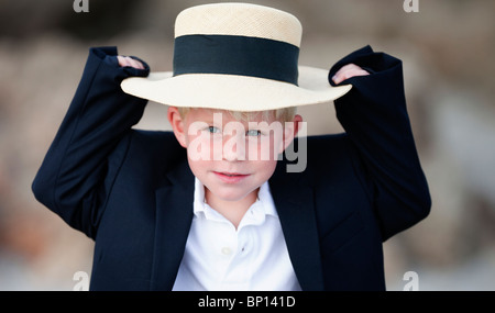 Junge hält seinen Hut Stockfoto
