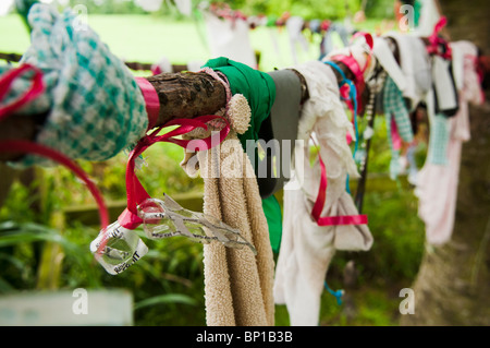 Bänder, Tuch und Geschenke hängen von den Zweigen eines Baumes am gut Heiligen Schrein für Saint Brigid von Kildare. Stockfoto