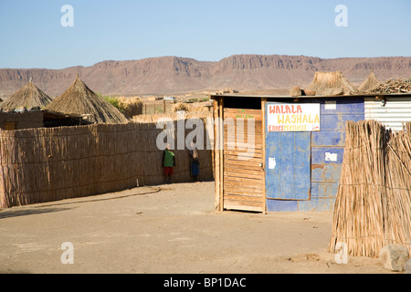 Aussenkehr Dorf - zwei Männer im Schatten von Schilf Zaun - Süden Namibias Stockfoto