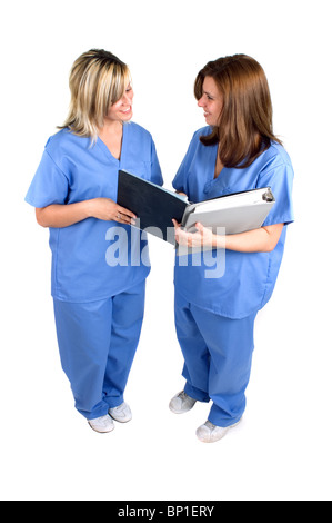 Zwei Krankenschwestern tragen Krankenhaus Scrubs sprechen, Isolated Over White Stockfoto