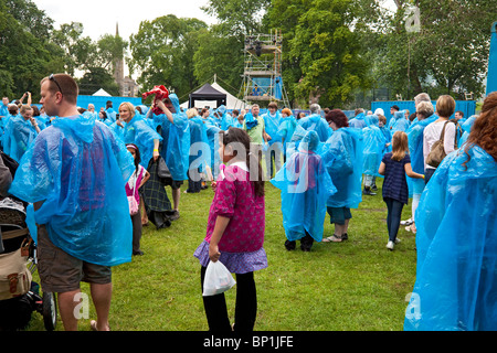 Publikum angezogen schützend in blauen Ponchos warten auf den Start von einer Aufführung des Stücks Cargo bei Edinburgh Mela, Schottland Stockfoto