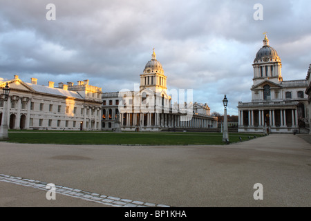 Innenhof des Royal Naval College, Greenwich, London, England, UK mit Abendlicht auf die Türme und grau gefleckte Himmel Stockfoto