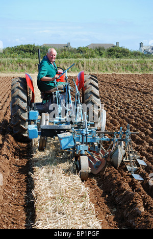 Landwirt mit einem Oldtimer-Traktor um zu pflügen ein Feld, Cornwall, uk Stockfoto