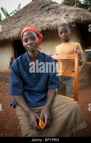 Eine junge Frau und ihr Bruder sitzt draußen ihre-Grass-Haus in Kisumu, Kenia. Stockfoto