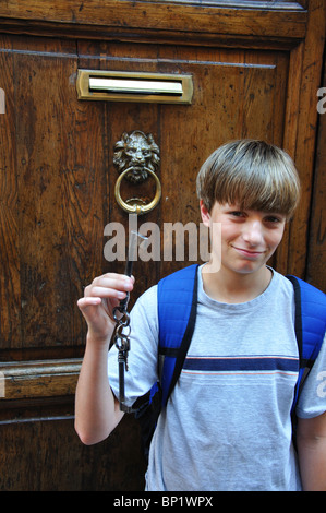 Teenager ist einen große alte Schlüssel vor einer Wohnungstür in Rom Italien Stockfoto