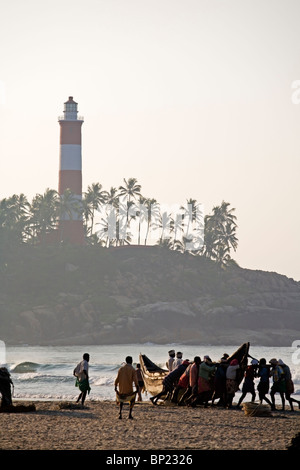 Indien. Kerala. Kovalam Beach. Lokale Fischer bereitet sich ein Fishingboat ins Meer am Strand von Kovalam zu schieben. 2006 Stockfoto