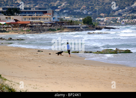 Frau mit Hund am Strand entlang spazieren Stockfoto