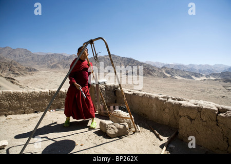 Sehr junger Mönch auf dem Dach Anlaufen der Mittagszeit die anderen Mönche Thikse Gompa. Stockfoto