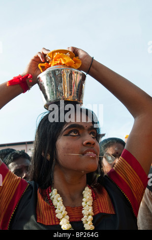 Hindu Anhänger mit genäht Wangen mit einem Lota mit Wasser während Thaipusam Festival in Batu Caves. Stockfoto