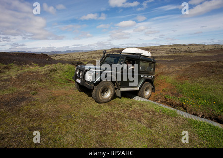 Land Rover Defender 90 300TDI navigiert einen gewaschenen Weg im Hochland von Island Stockfoto